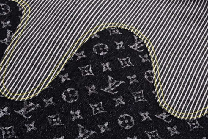 Tessuto di lusso con monogramma LV, strisce bianche e dettagli di cucitura gialla.