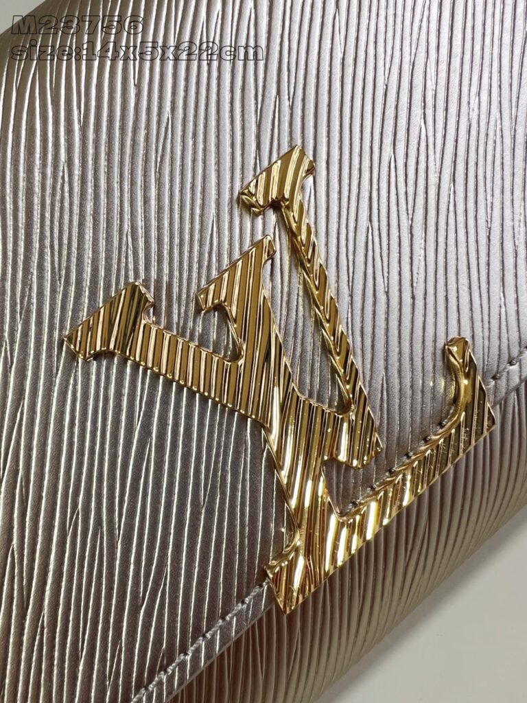 Logo di alta moda in oro su superficie argento con texture elegante e dettagli raffinati.