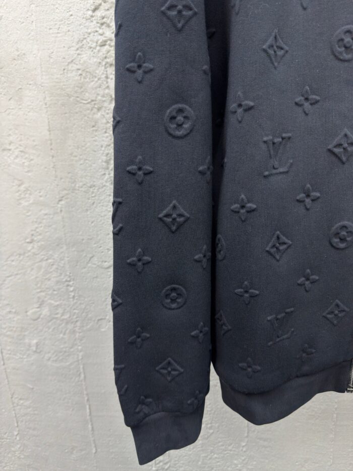 Manica di pullover nero con motivo embossato elegante e dettagli di moda di alta qualità.