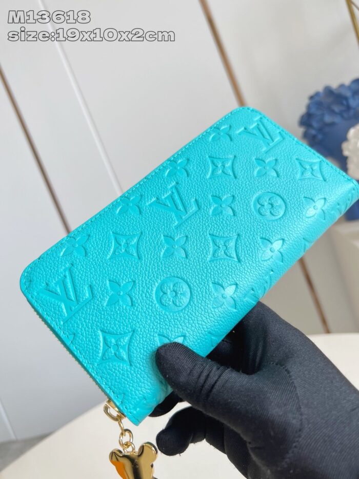 Portafoglio di lusso turchese con charm farfalla e loghi embossed, elegante e di alta qualità.