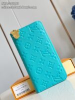 Portafoglio turquoise di lusso con monogramma, dettaglio oro e elegante confezione arancione.