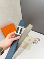 Cintura di lusso blu e grigia con fibbia minimalista in metallo, elegante e moderna.