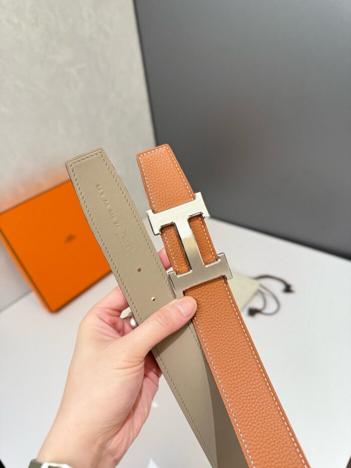 Cintura in pelle a due toni con fibbia moderna e design elegante, perfetta per ogni occasione.