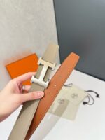 Cintura in pelle bicolore con fibbia moderna, elegante e versatile per ogni outfit di lusso.