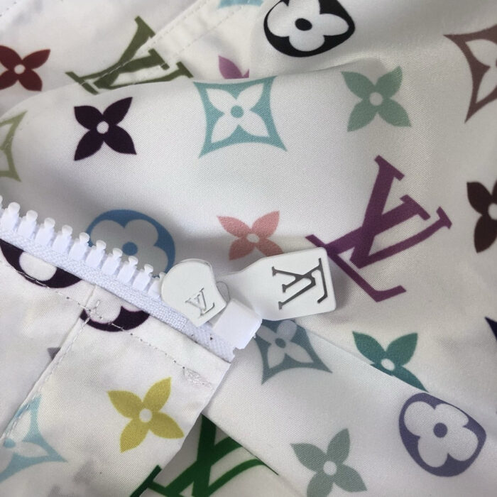 Dettaglio di tessuto Louis Vuitton con fiori, zip logo e stile di alta moda.