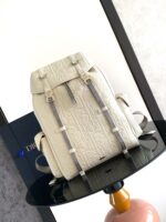 Zaino bianco di lusso in pelle con dettagli eleganti su tavolo circolare raffinato.