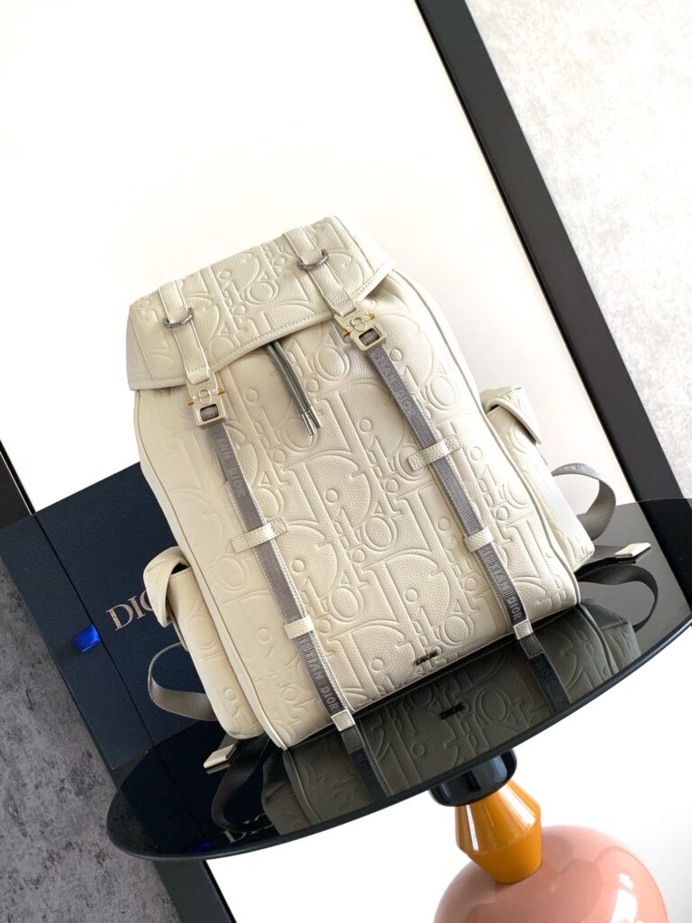 Zaino bianco di lusso in pelle con dettagli eleganti su tavolo circolare raffinato.