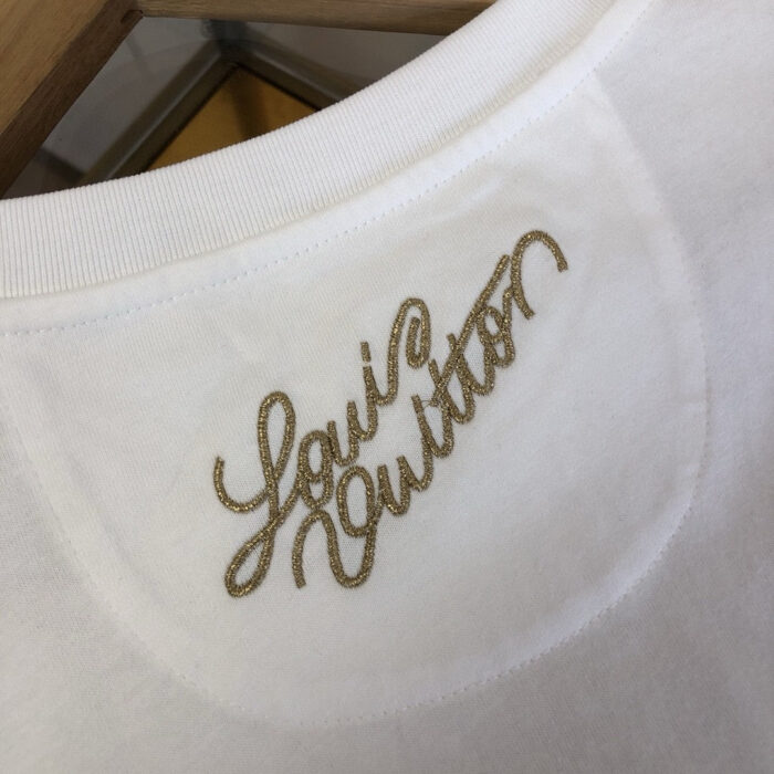Maglietta bianca con ricamo Louis Vuitton oro sul retro del scollo classico.
