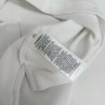 Tessuto bianco di alta qualità con etichetta di cura, elegante e resistente.