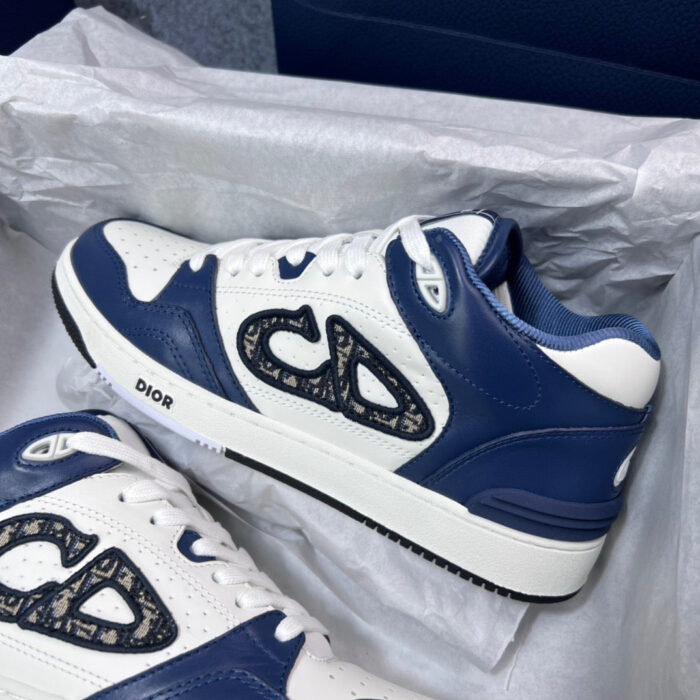 Sneakers Dior bianche e navy, design moderno con logo di lusso, perfette per ogni occasione.
