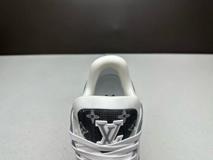 Sneaker di lusso nera e bianca dal design elegante con logo in rilievo e dettagli raffinati.