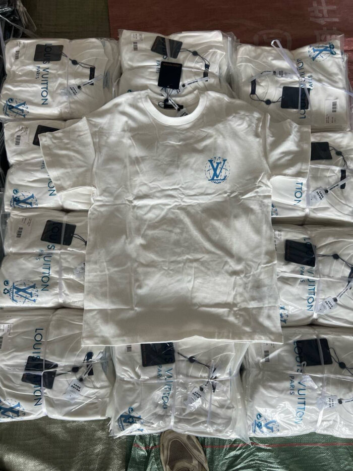 T-shirt bianca Louis Vuitton con logo, esposizione di alta moda e lusso raffinato.