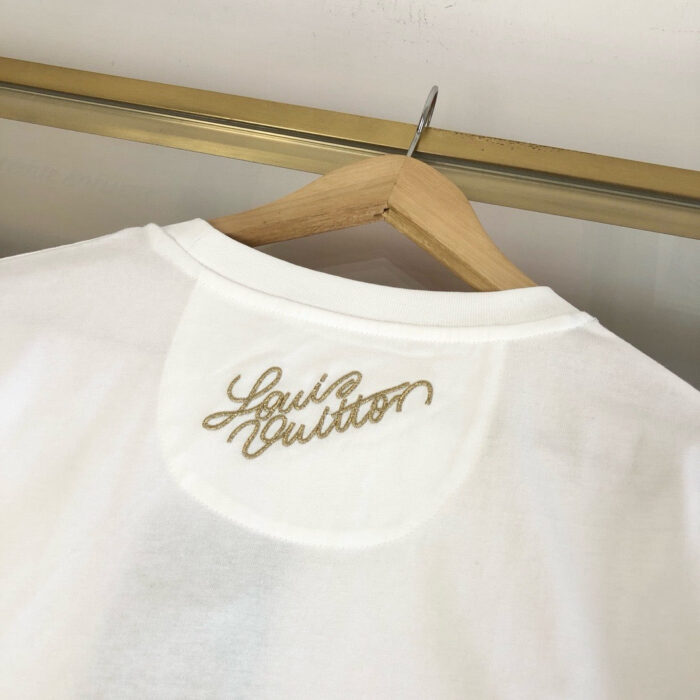 Maglietta bianca Louis Vuitton con ricamo dorato sul retro, look elegante e versatile.