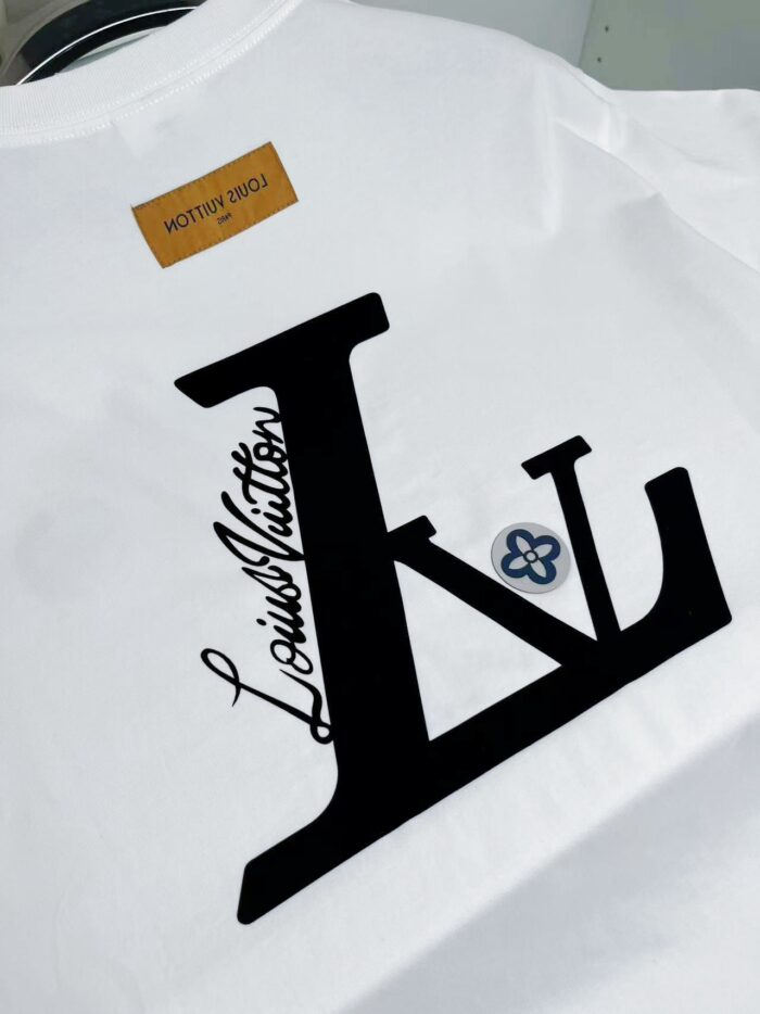T-shirt bianca Louis Vuitton con logo stilizzato, fiore decorativo e dettagli di lusso.