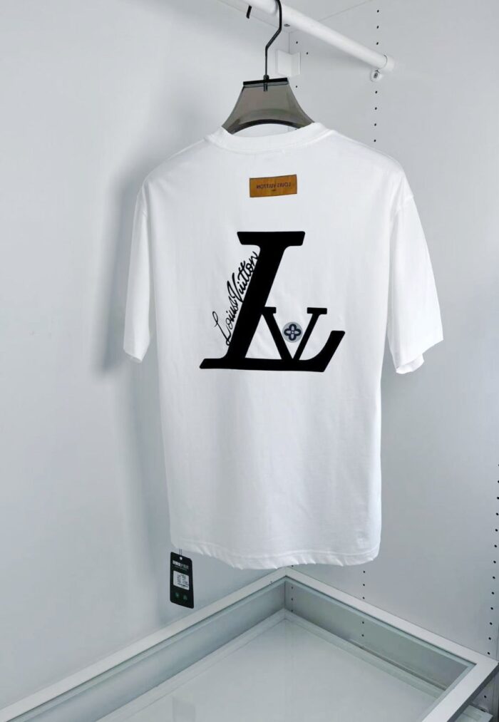 T-shirt bianca di lusso con logo stilizzato e dettaglio in pelle, stile moderno ed elegante.