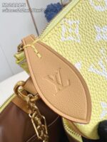 Borsa Louis Vuitton gialla con dettagli in pelle, fiocco dorato e interno spazioso elegante.