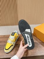 Sneaker Louis Vuitton gialla con dettagli neri, suola logo e design moderno di lusso.