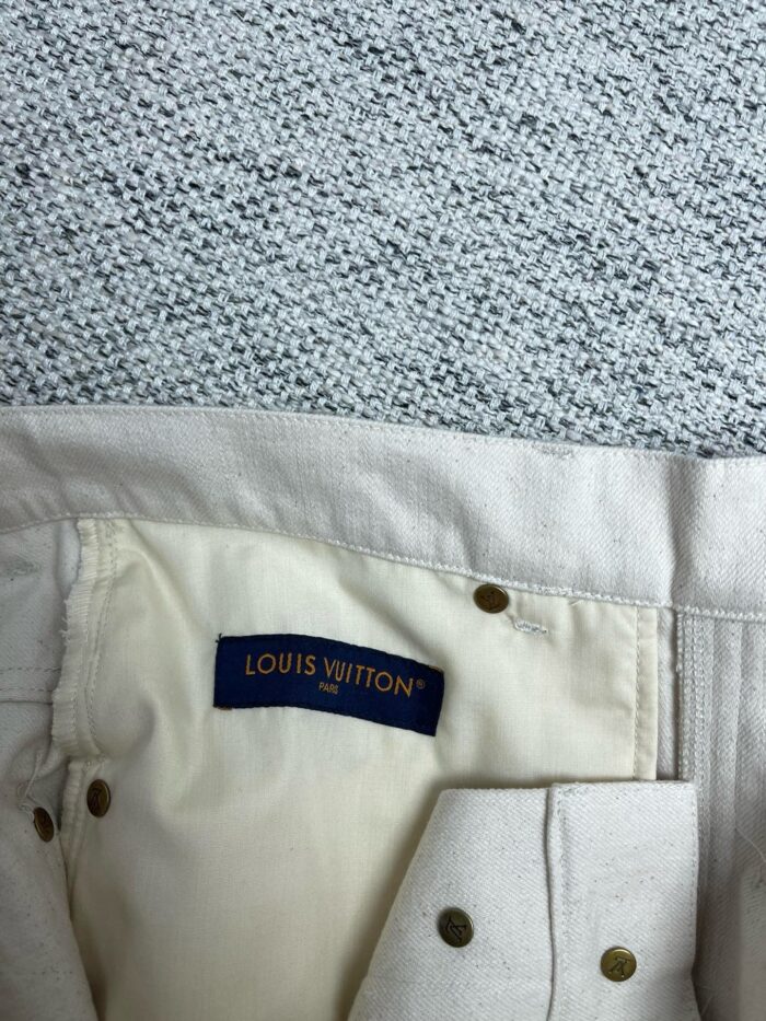 Etichetta interna Louis Vuitton su abbigliamento di lusso, dettagli eleganti e materiali pregiati.