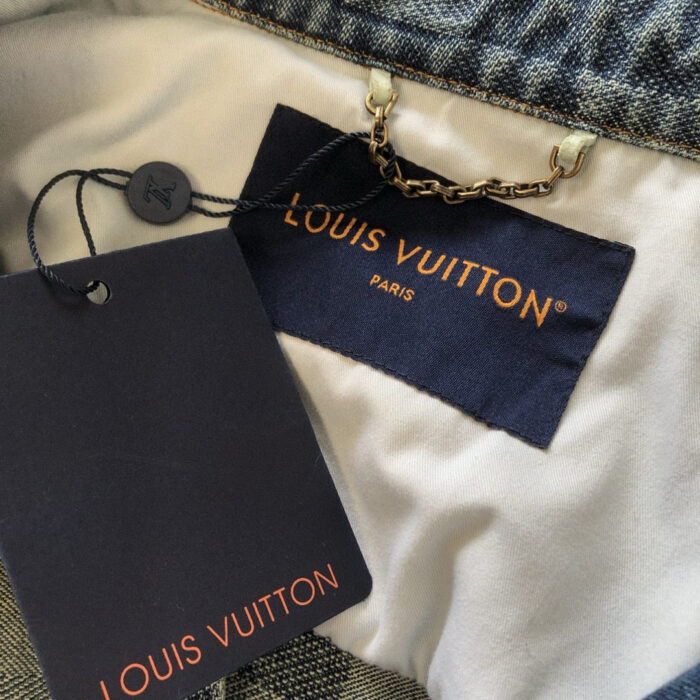 Etichetta interna Louis Vuitton con logo in rilievo e dettaglio elegante.