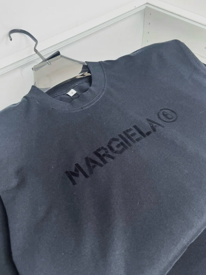 Maglione nero Maison Margiela con logo ricamato minimalista su tessuto morbido e comodo.