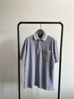 Maglietta polo grigia uomo con colletto a righe e tasca, stile casual elegante.