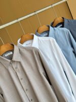 Set di camicie da uomo colorate su gruccia di legno, stile elegante e versatile.