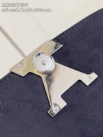 Fermaglio elegante in metallo argentato su suède nero per borse di alta moda.