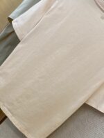 Maglietta beige semplice, casual e minimalista, ideale per uno stile comodo e versatile.