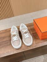 Scarpe beige in suede con scatola arancione, stile moderno, arredamento elegante.