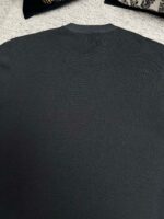 Maglione grigio classico con collo rotondo e dettagli discreti sul retro.
