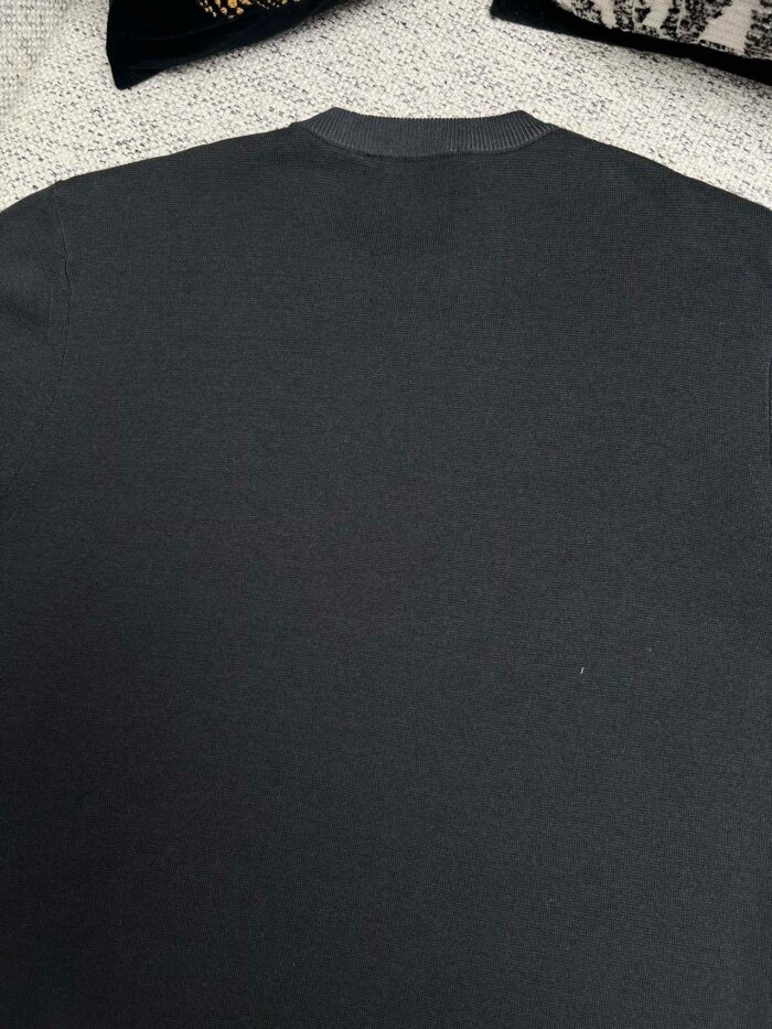 Maglione grigio classico con collo rotondo e dettagli discreti sul retro.
