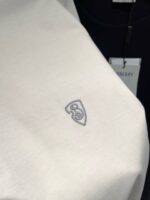 Camicia bianca minimalista con logo ricamato, tessuto morbido e stile elegante versatile.