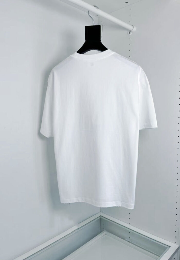 Maglietta bianca classica su appendiabiti nero, stile minimalista e versatile, ideale per ogni outfit.