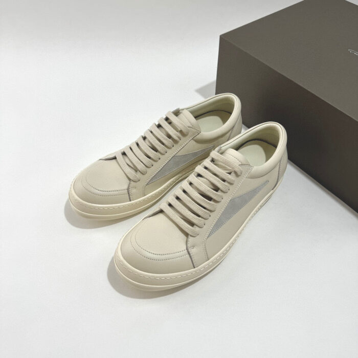 Sneakers beige in pelle minimaliste ed elegante, con dettagli sobri e design versatile.