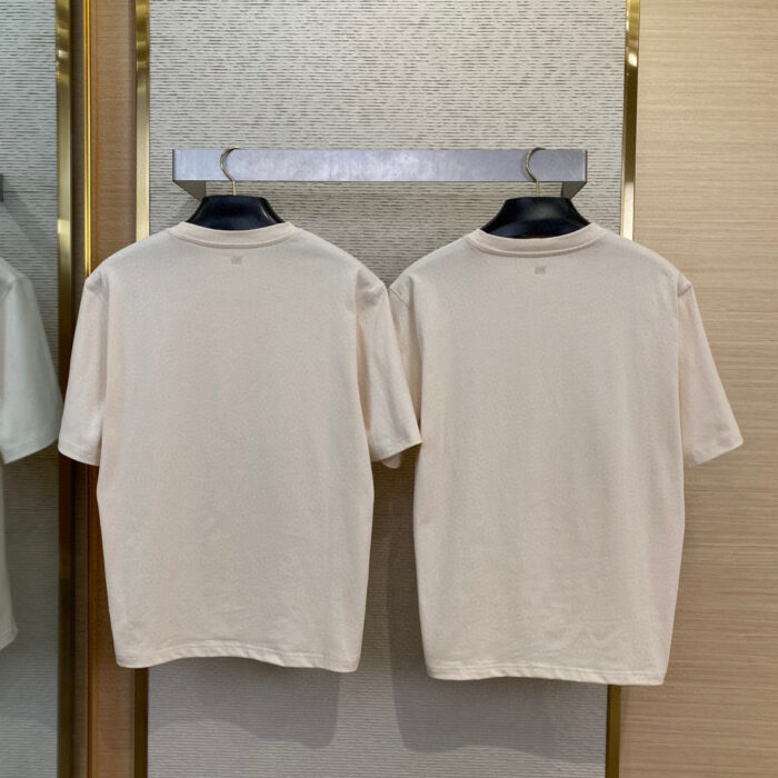 Paio di T-shirt beige minimaliste casual su attaccapanni moderno, stile neutro e versatile.