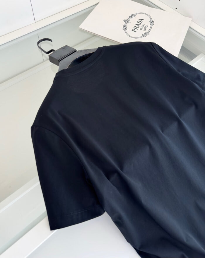Maglietta nera casual e moderna su sfondo minimalista con logo elegante.