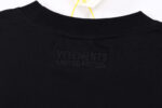 Maglietta nera VETEMENTS Limited Edition con logo embossato e etichetta gialla elegante.