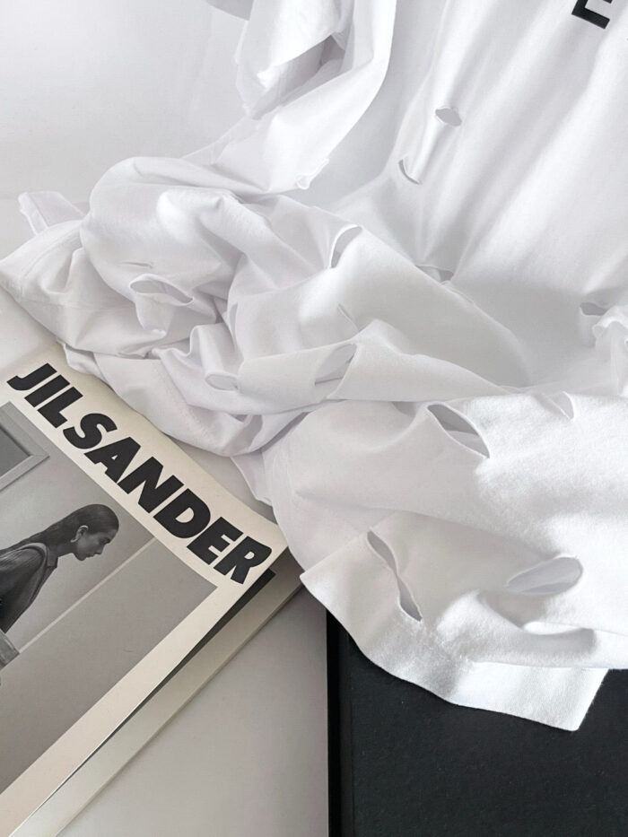 Camicetta bianca volutamente stropicciata su rivista Jil Sander in stile minimalista.