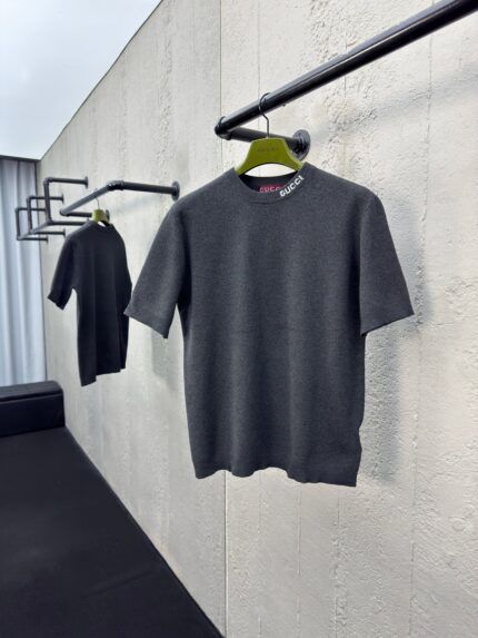 Maglioni grigi minimalisti su rack nero in vetrina moderna, stile semplice e sofisticato.