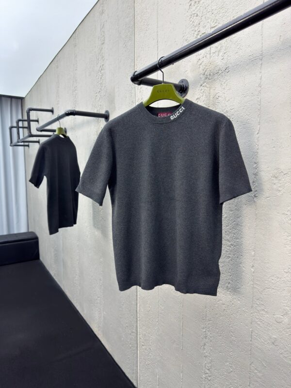 Maglioni grigi minimalisti su rack nero in vetrina moderna, stile semplice e sofisticato.