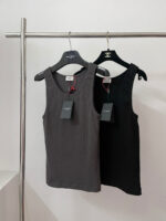 Top senza maniche grigio e nero su scaffale moderno, ideale per look casual e alla moda.