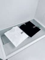 Magliette bianca e nera con OK in vetrina minimalista e moderna