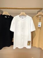 Set di T-shirt casual in nero, bianco e beige, stile minimalista su esposizione elegante.