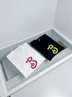 Magliette moderne con logo colorato su esposizione minimalista in teca di vetro