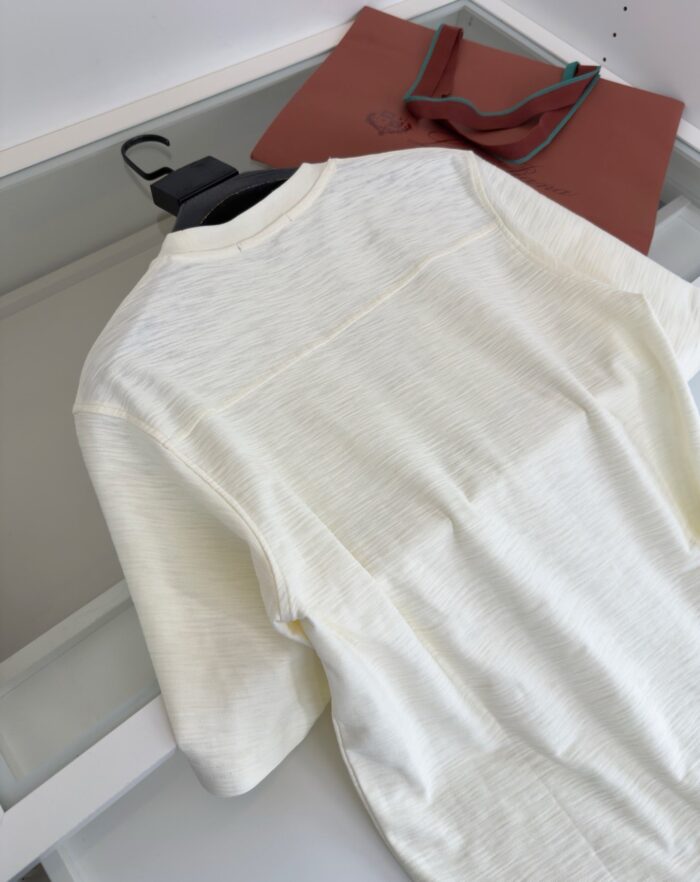 Camicia crema minimalista con borsa marrone, stile elegante e semplice per ogni occasione.