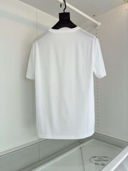 Maglietta bianca semplice su gruccia nera in ambiente minimalista, perfetta per stile casual e versatile.
