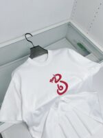 T-shirt bianco con grafica di serpente rosso, stile minimalista e design moderno.
