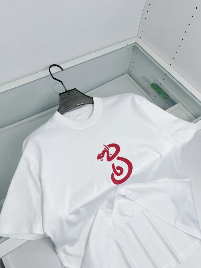 T-shirt bianco con grafica di serpente rosso, stile minimalista e design moderno.