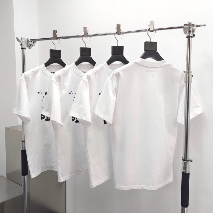 Esposizione minimalista di magliette bianche su supporto moderno in ambiente retail elegante.