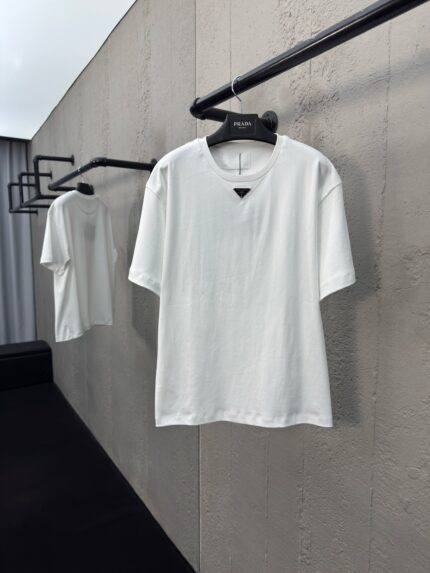 Maglietta bianca minimalista con scollo a triangolo, stile casual chic, ambiente moderno e sobrio.